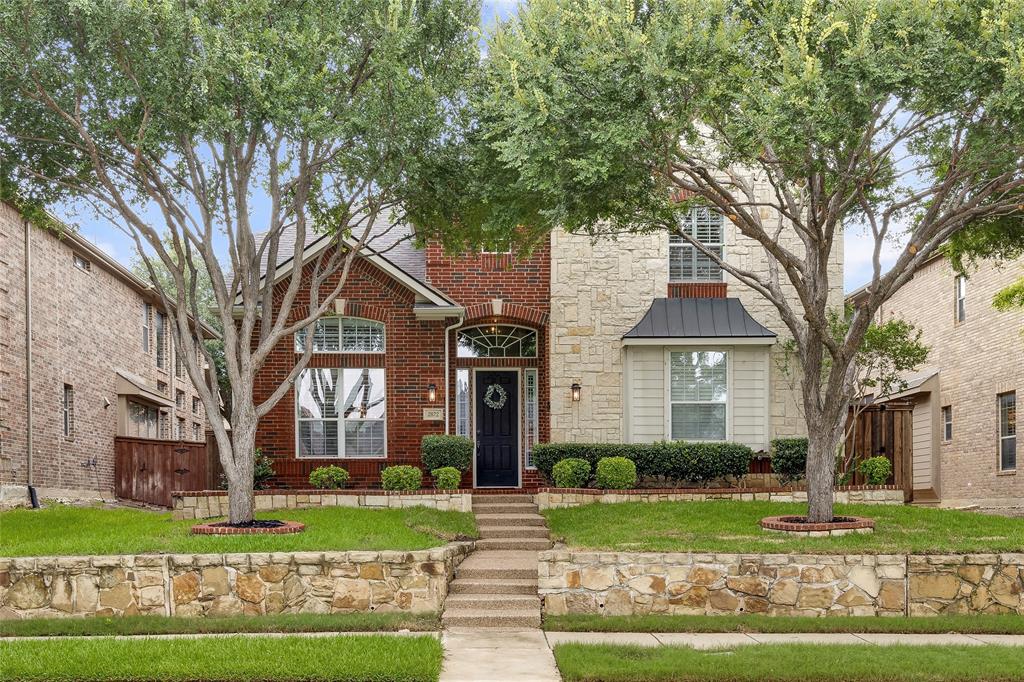 a front view of a house with a yard and an trees