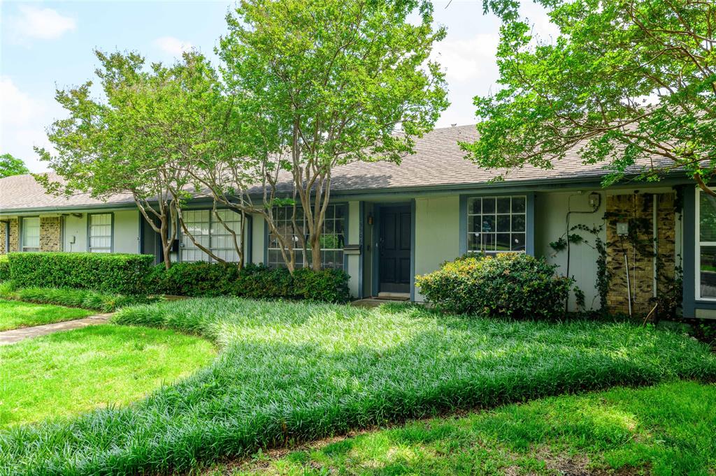 a view of garden with plants and trees in front of house