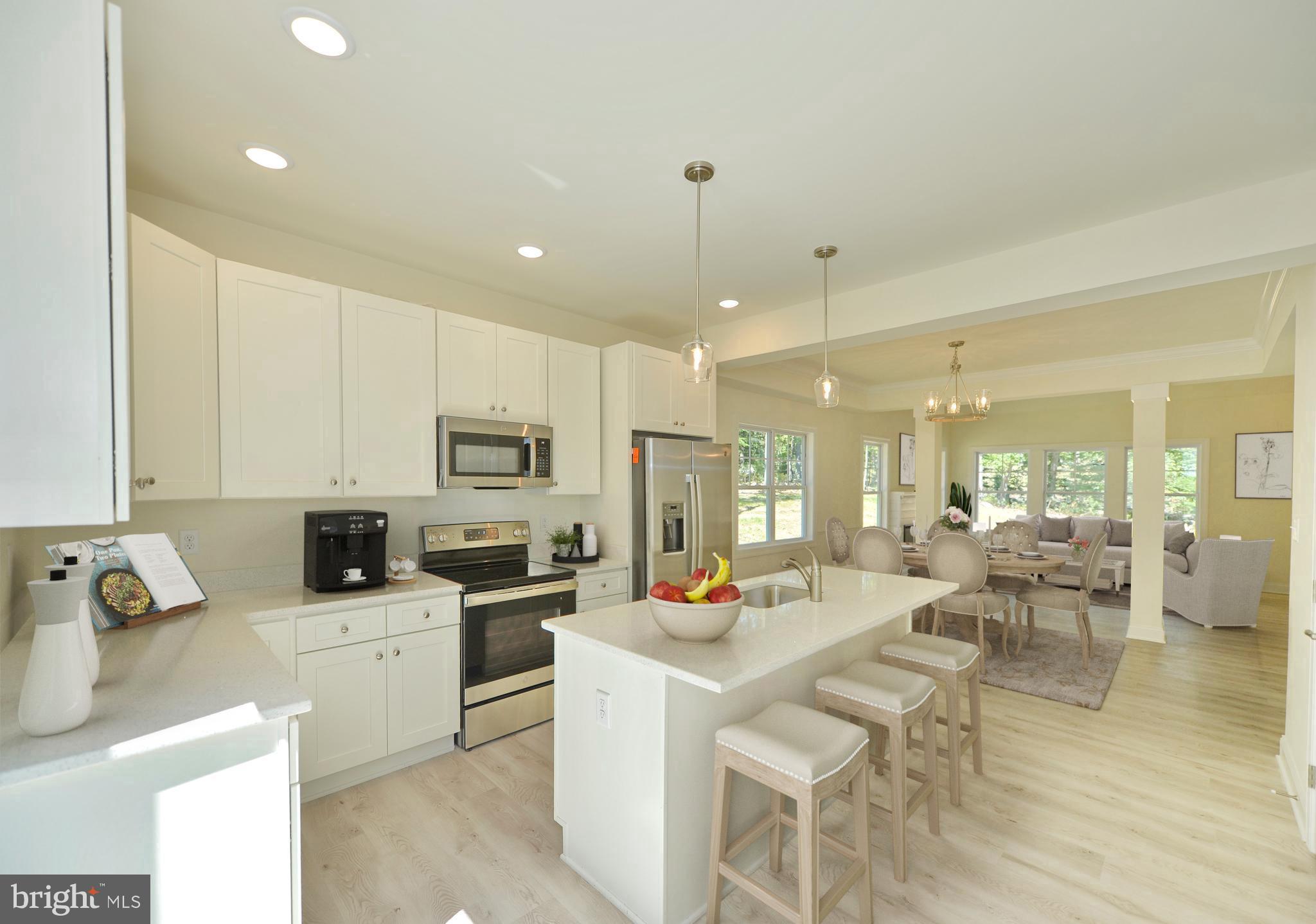 a large white kitchen with lots of counter space and stainless steel appliances