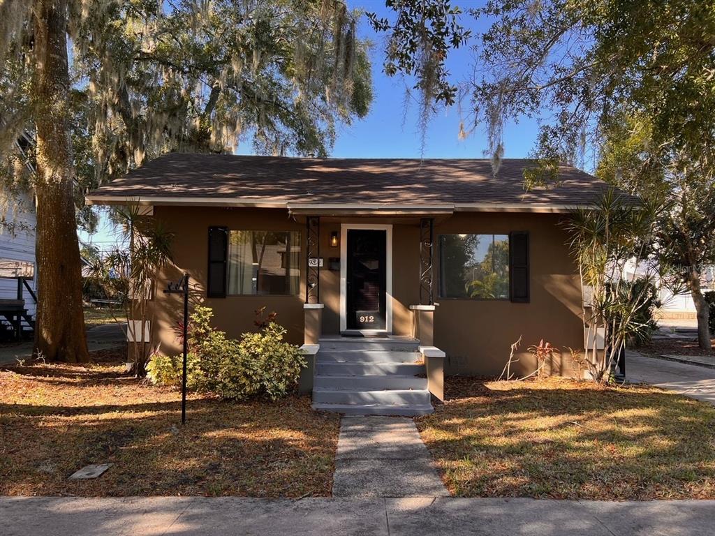 a front view of a house with a tree