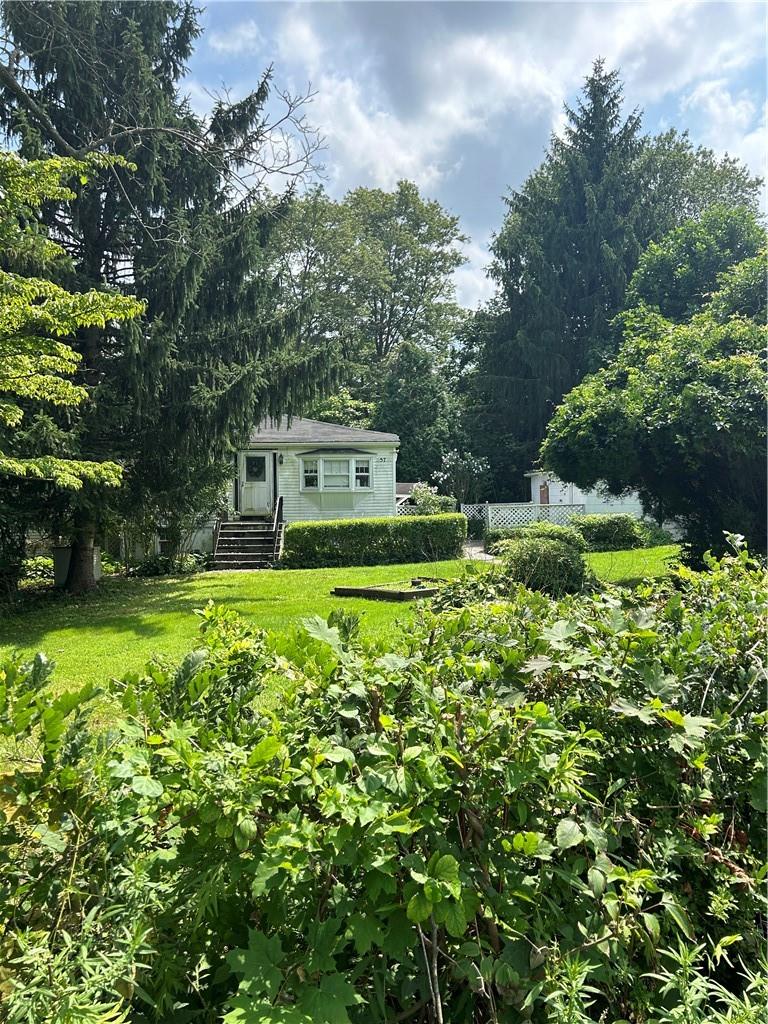 a view of a house with a yard and sitting area