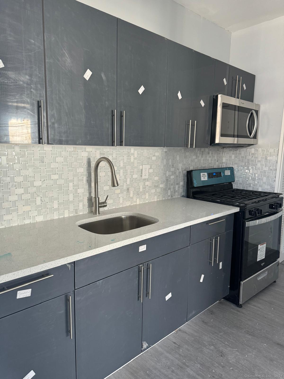 a kitchen with a sink cabinets and stainless steel appliances