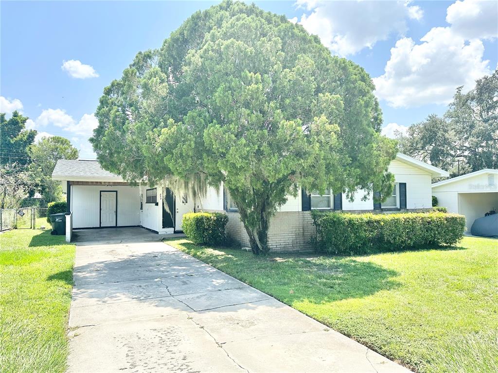 a front view of a house with a yard and trees