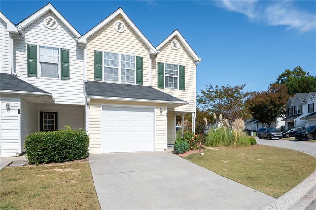 a view of a house with a yard and garage