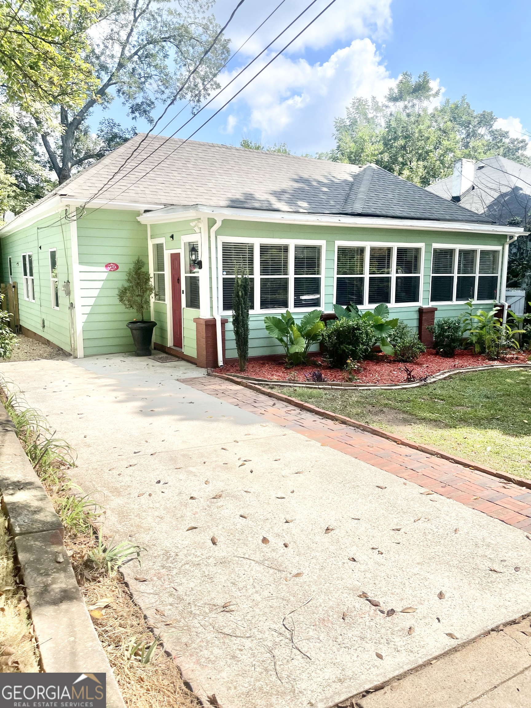 a front view of a house with a yard and potted plants