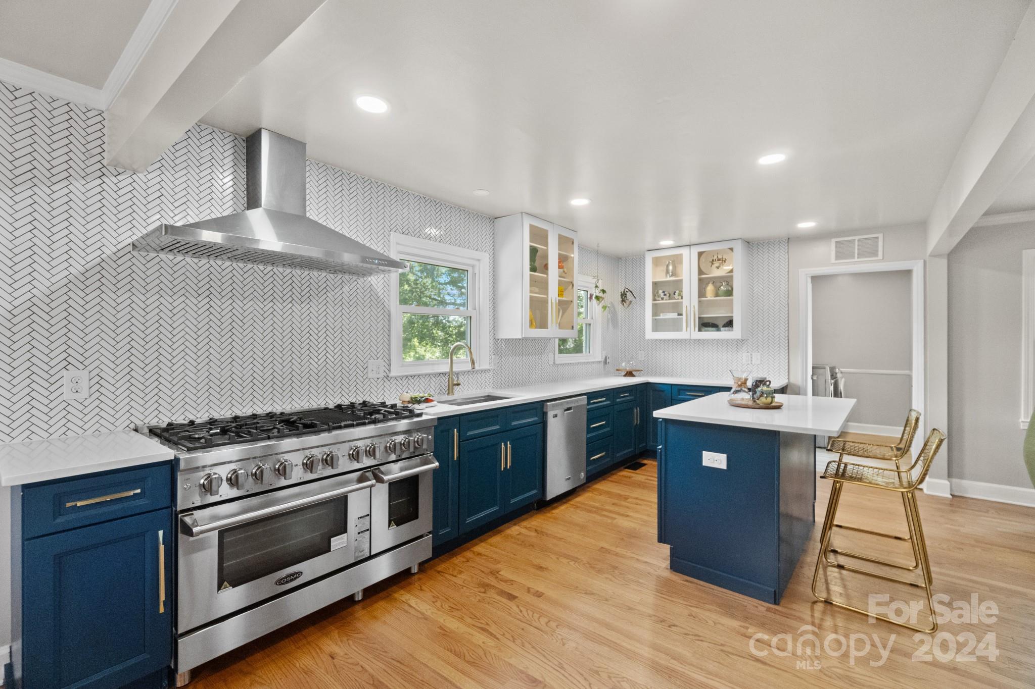 a kitchen with stainless steel appliances granite countertop a stove a sink dishwasher and a refrigerator