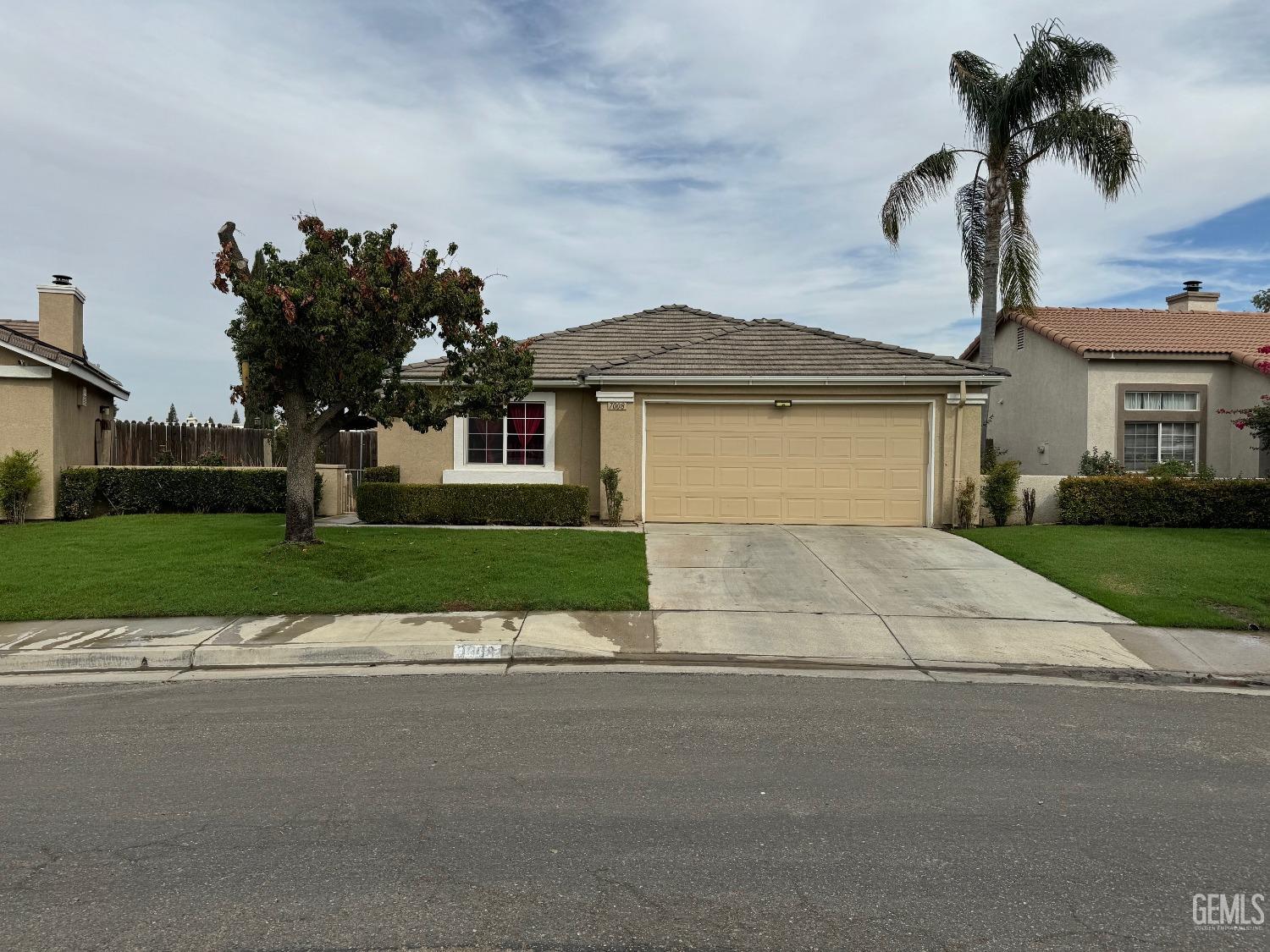 a front view of a house with a garden and a garage