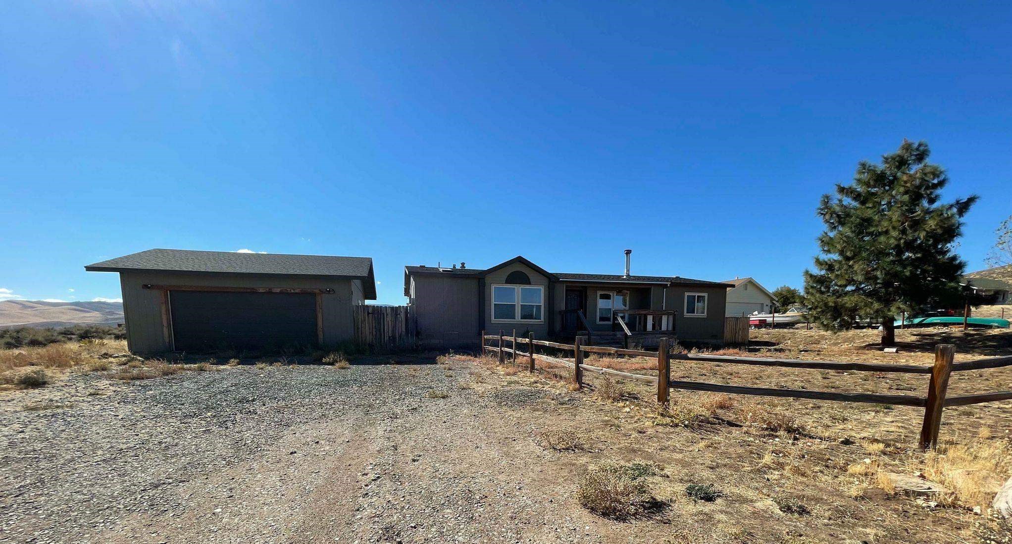 a view of a dry yard with wooden fence