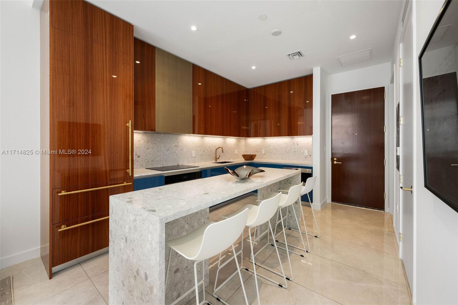 a kitchen with stainless steel appliances kitchen island granite countertop a refrigerator and a sink