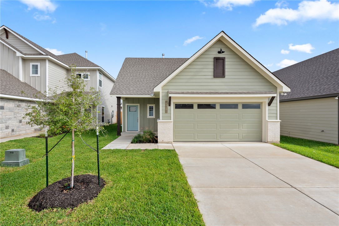 View of front facade with a garage and a front law