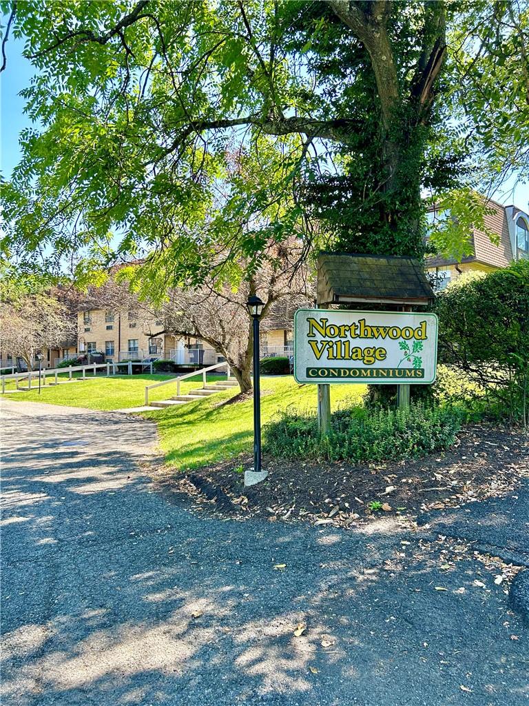 Community / neighborhood sign featuring a yard