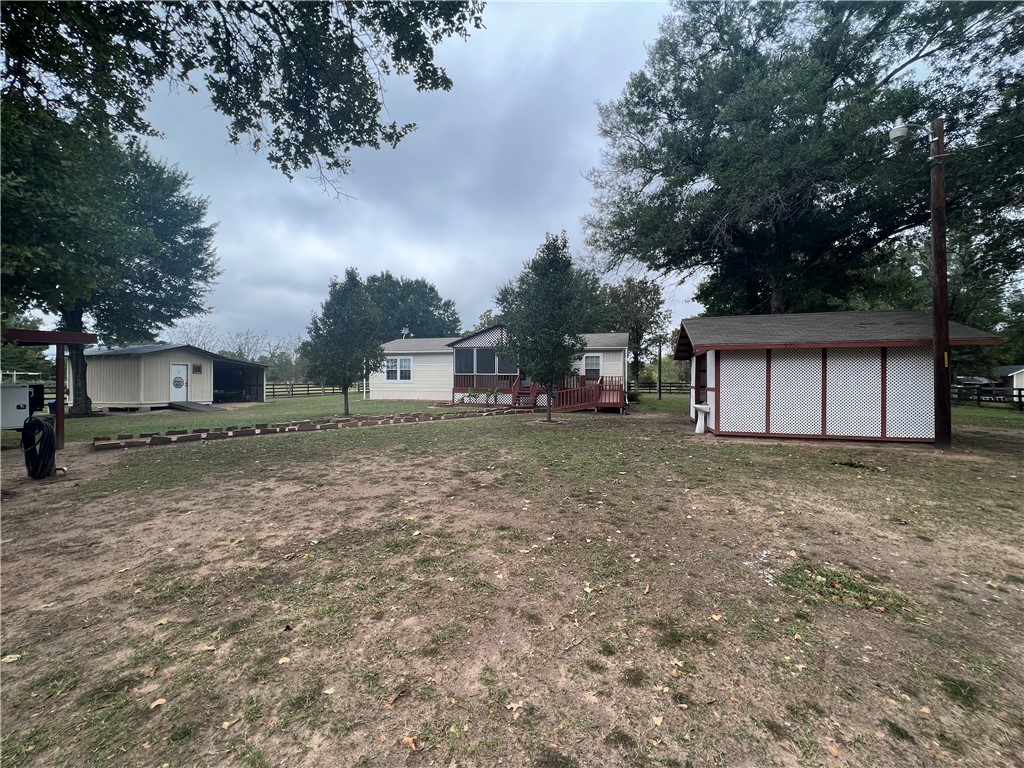 a view of a house with a backyard and bushes