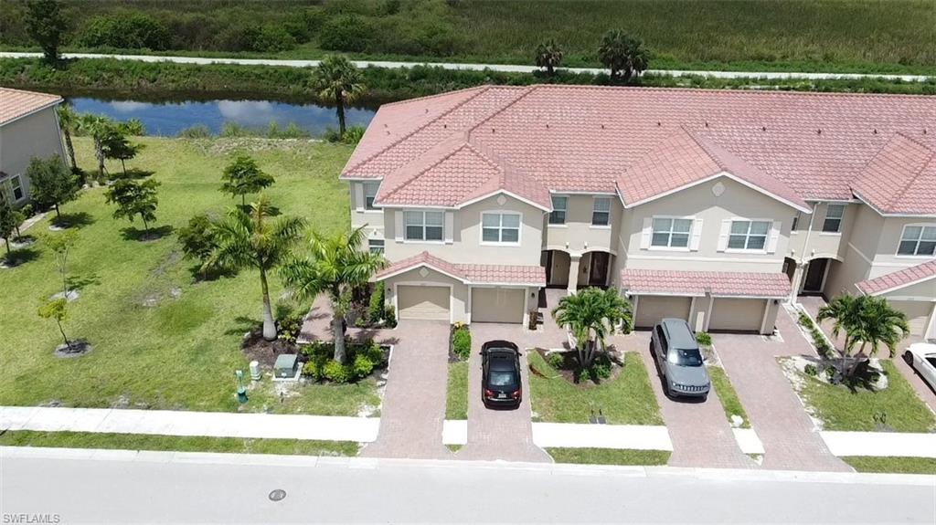 View of front of property with a garage and a water view