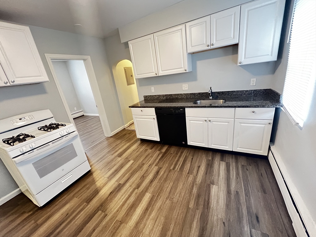 a kitchen with wooden floors and a stove