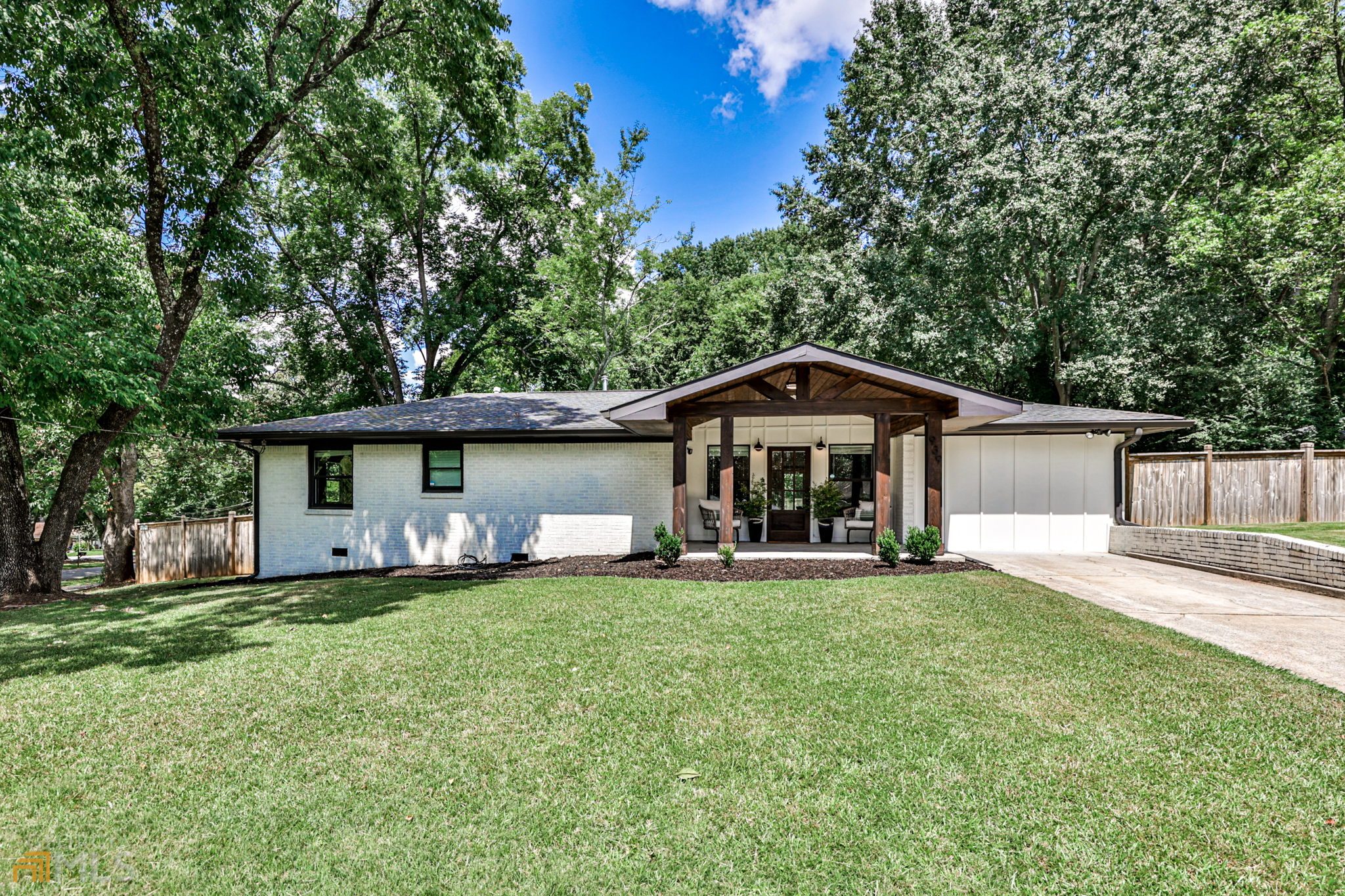 a front view of a house with a yard and trees