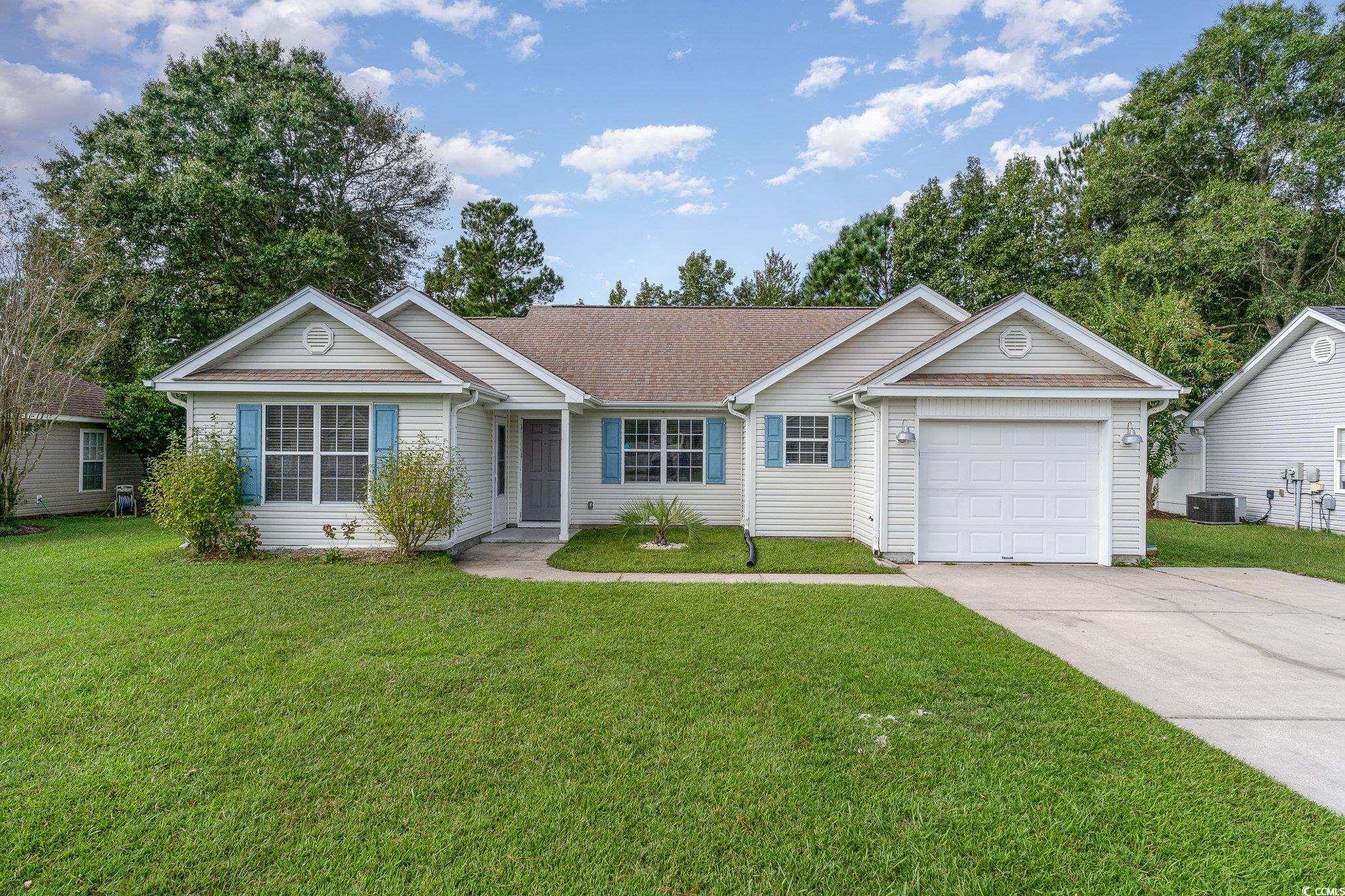 Ranch-style house with a front yard, a garage, and