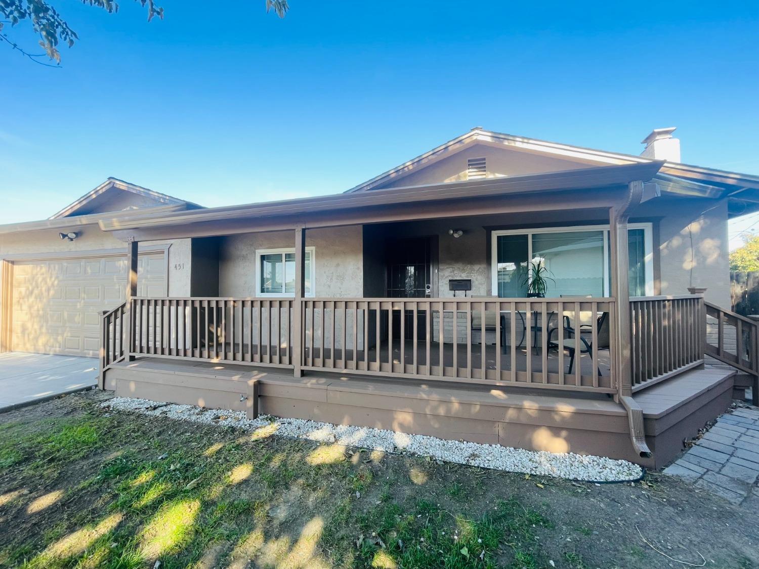 a view of a house with a deck and a yard