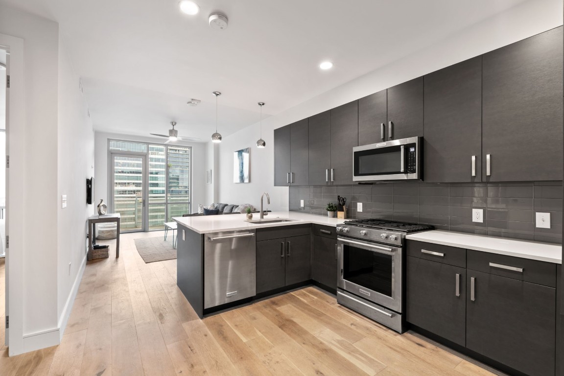 a large kitchen with stainless steel appliances granite countertop a stove and a sink