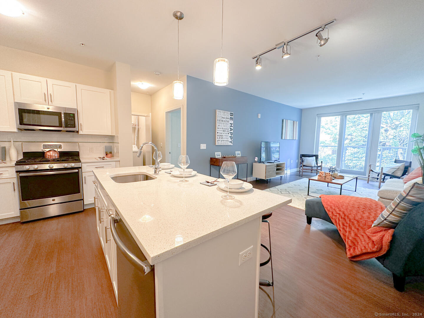 a kitchen with stainless steel appliances kitchen island granite countertop a stove and a refrigerator