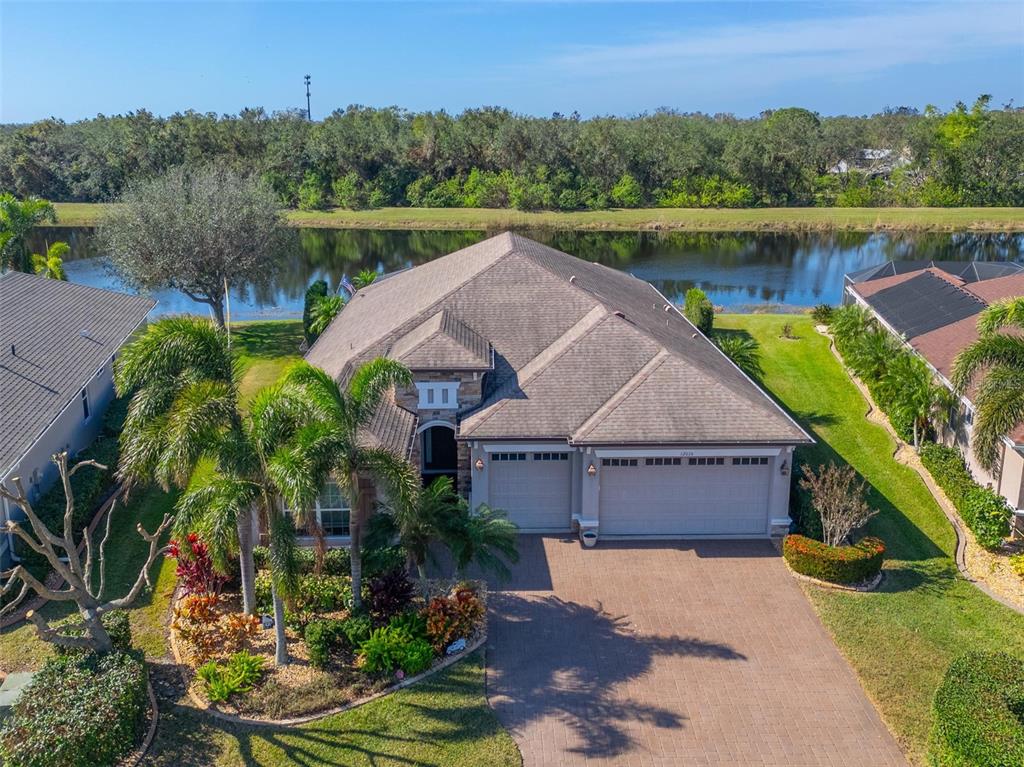 an aerial view of a house with a yard and lake view