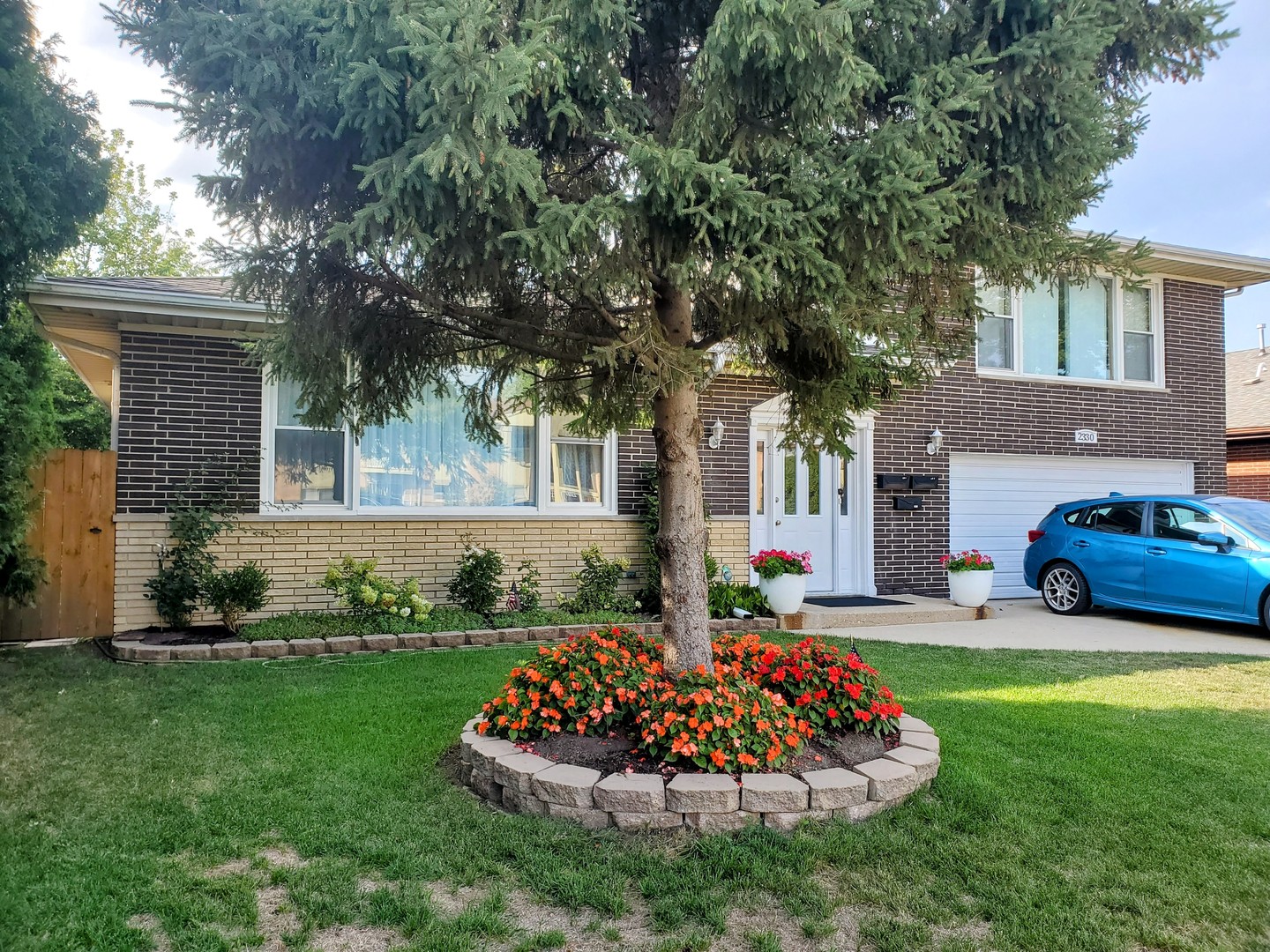 a front view of a house with a garden and yard