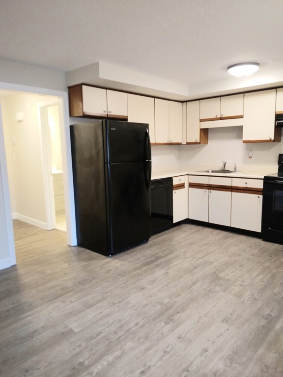 a kitchen with granite countertop a refrigerator and a sink