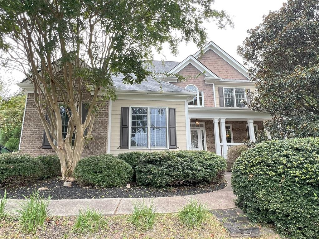 a front view of a house with a yard and potted plants