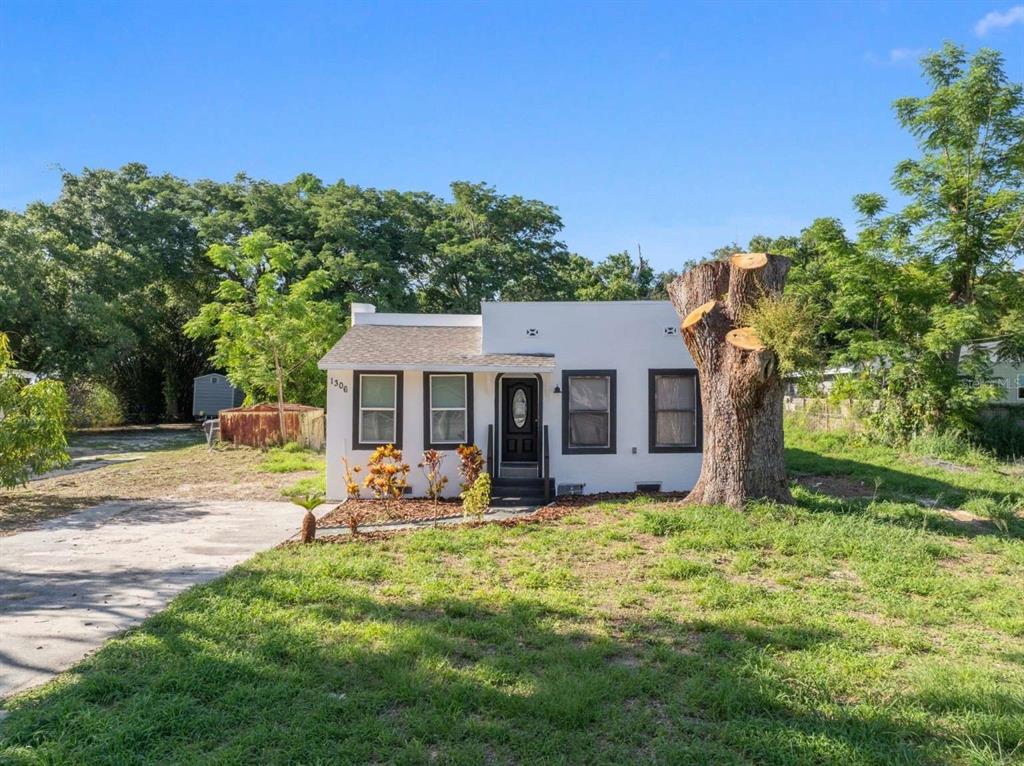 a view of a house with backyard and sitting area