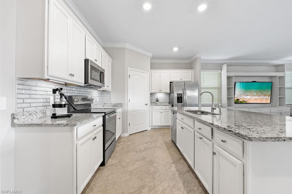 a kitchen with stainless steel appliances granite countertop a stove sink and cabinets