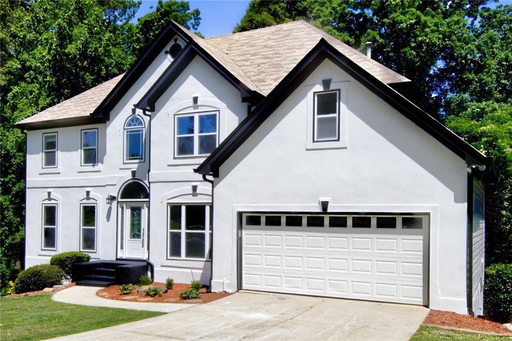 a front view of a house with a yard and garage