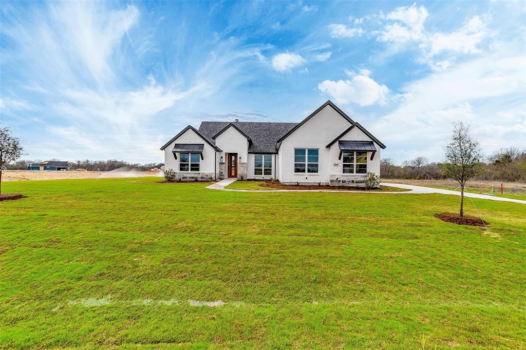 a front view of a house with a big yard