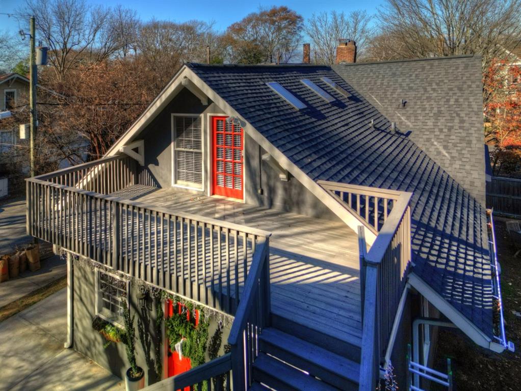 a view of a house with wooden deck stairs and furniture