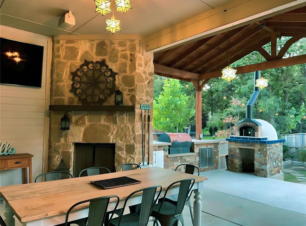 a patio with a fireplace a dining table and chairs with wooden floor