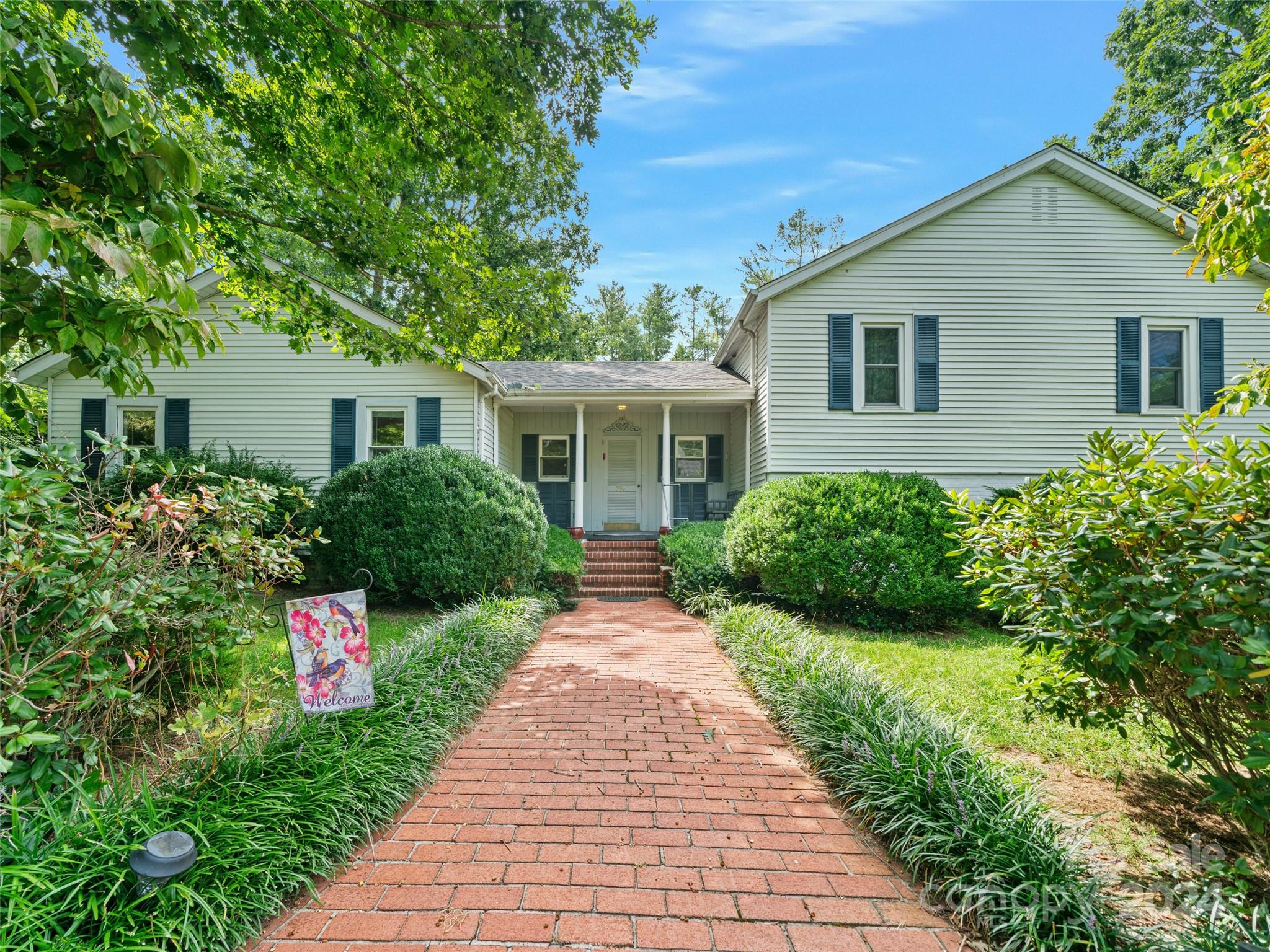 a front view of a house with a yard and potted plants