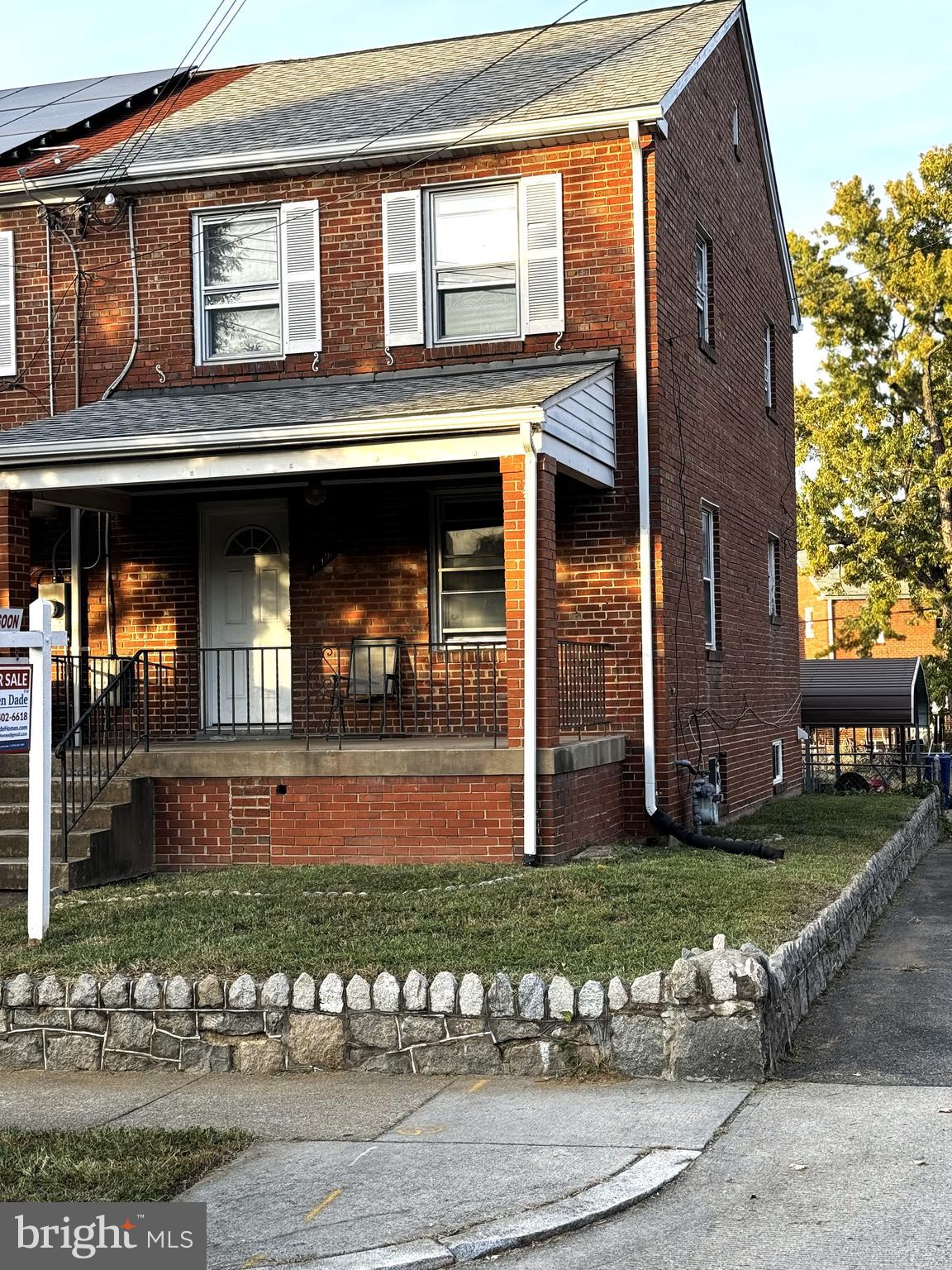 a view of a brick house with many windows and a yard