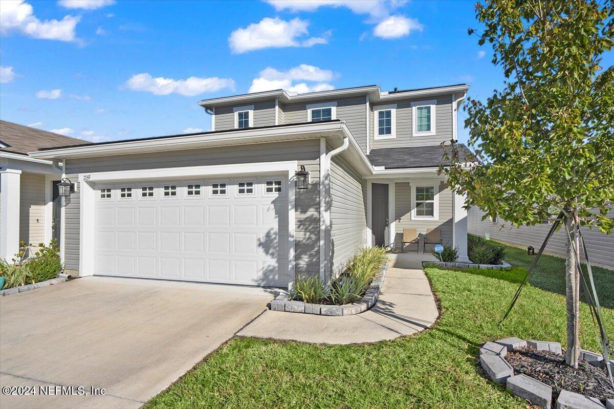 a front view of a house with a yard garage and outdoor seating