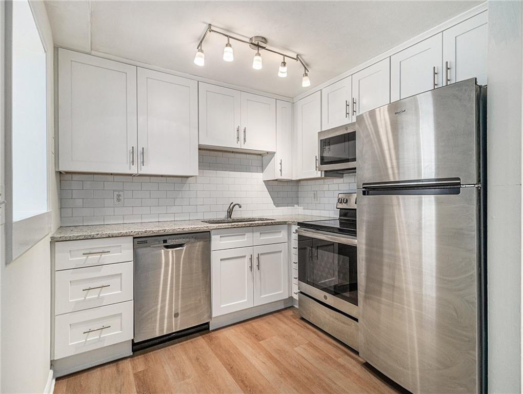 a kitchen with stainless steel appliances a refrigerator sink and cabinets