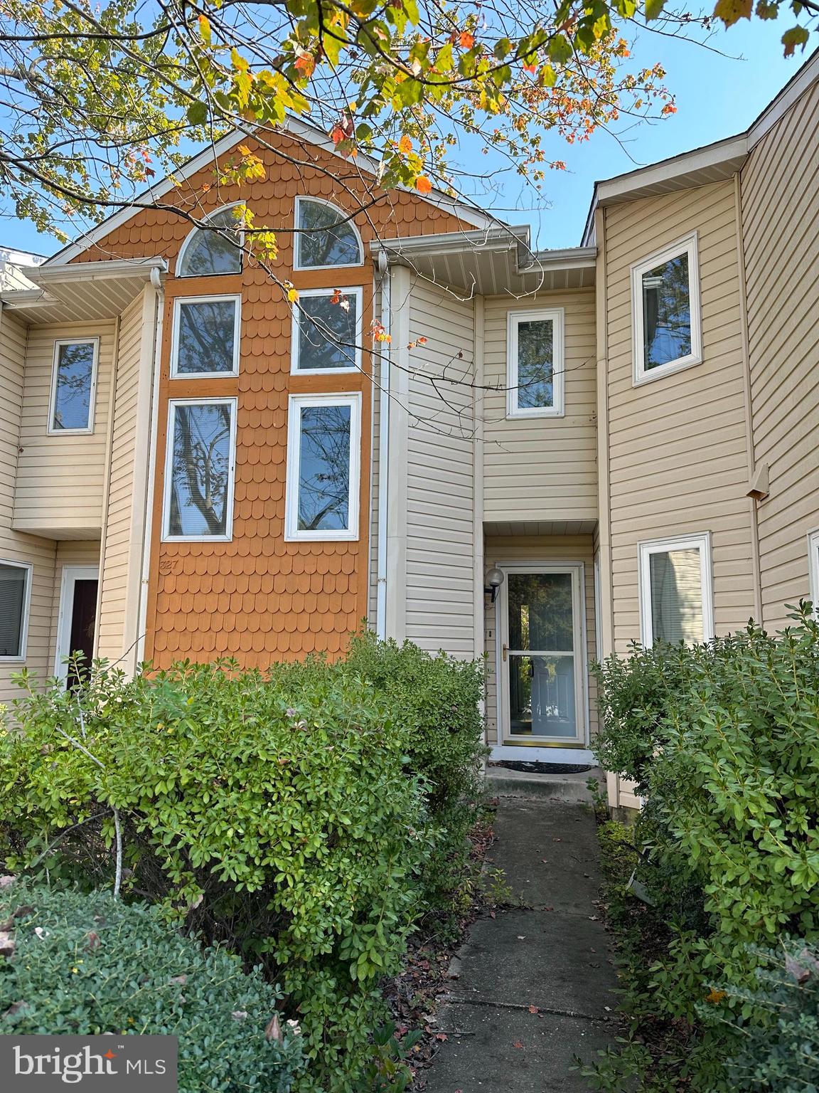 a front view of a house with plants and trees