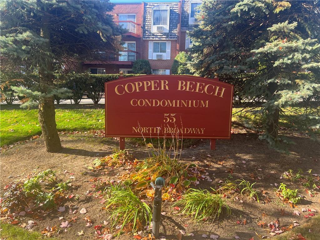 a sign of road with a building in the background