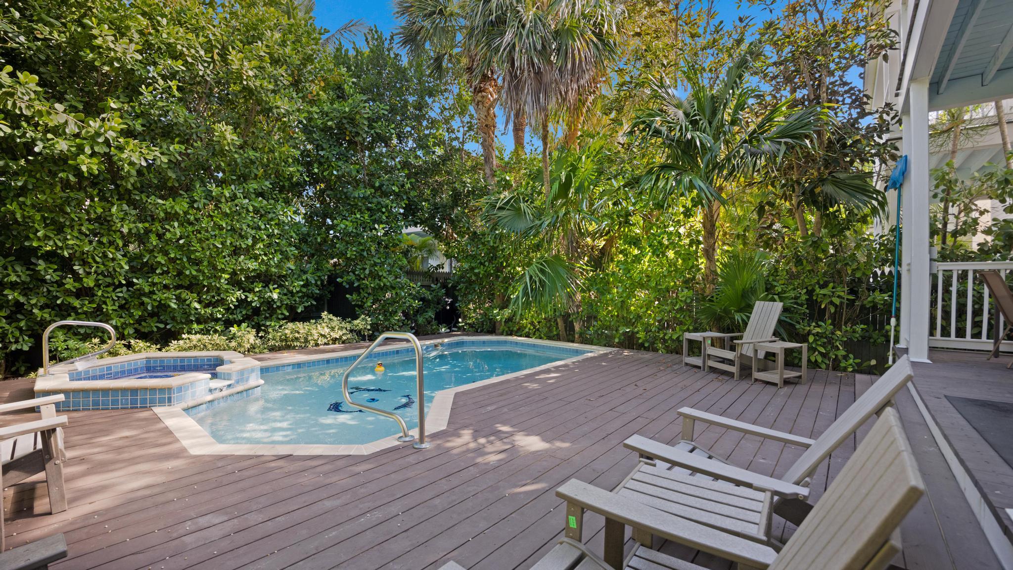 a view of a patio with table and chairs with wooden floor and fence