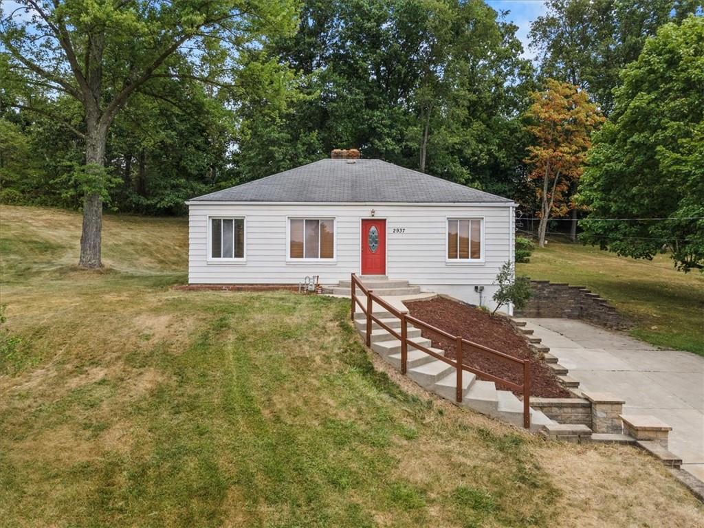 a view of a house with a yard and sitting area