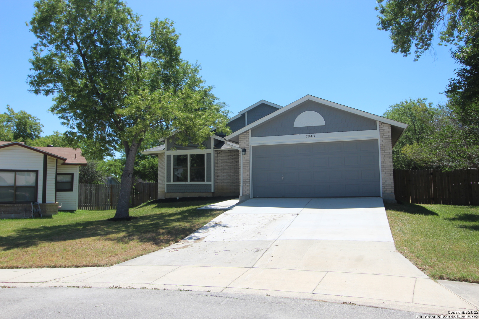 a front view of a house with a yard and trees