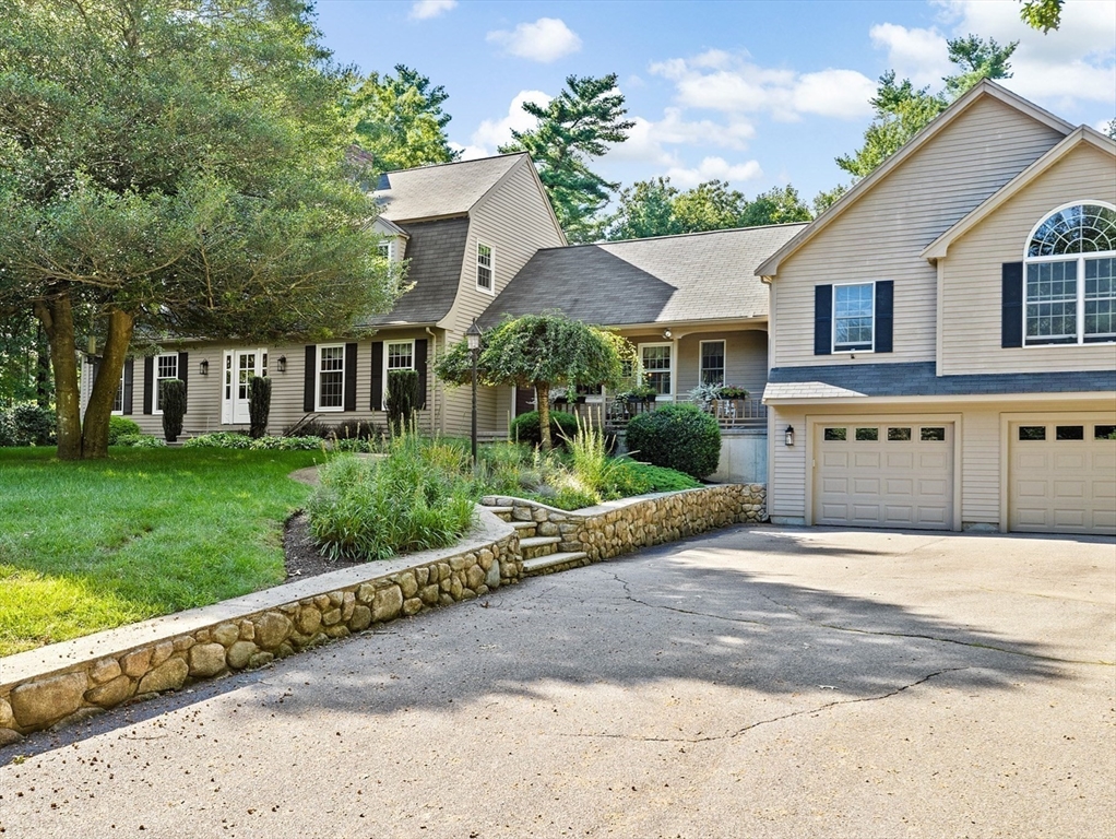 a front view of a house with a yard and potted plants