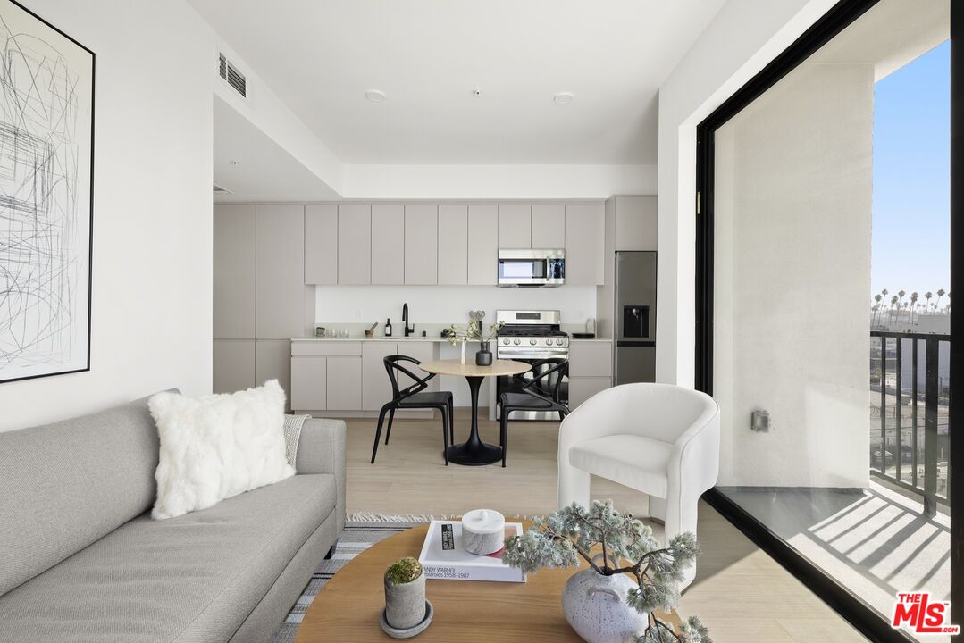 a living room with furniture and a dining table with chairs