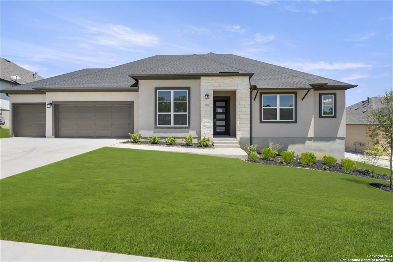 a front view of a house with a garden and yard