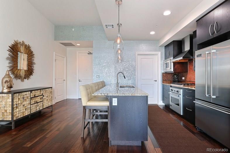 a kitchen with refrigerator a sink and chairs