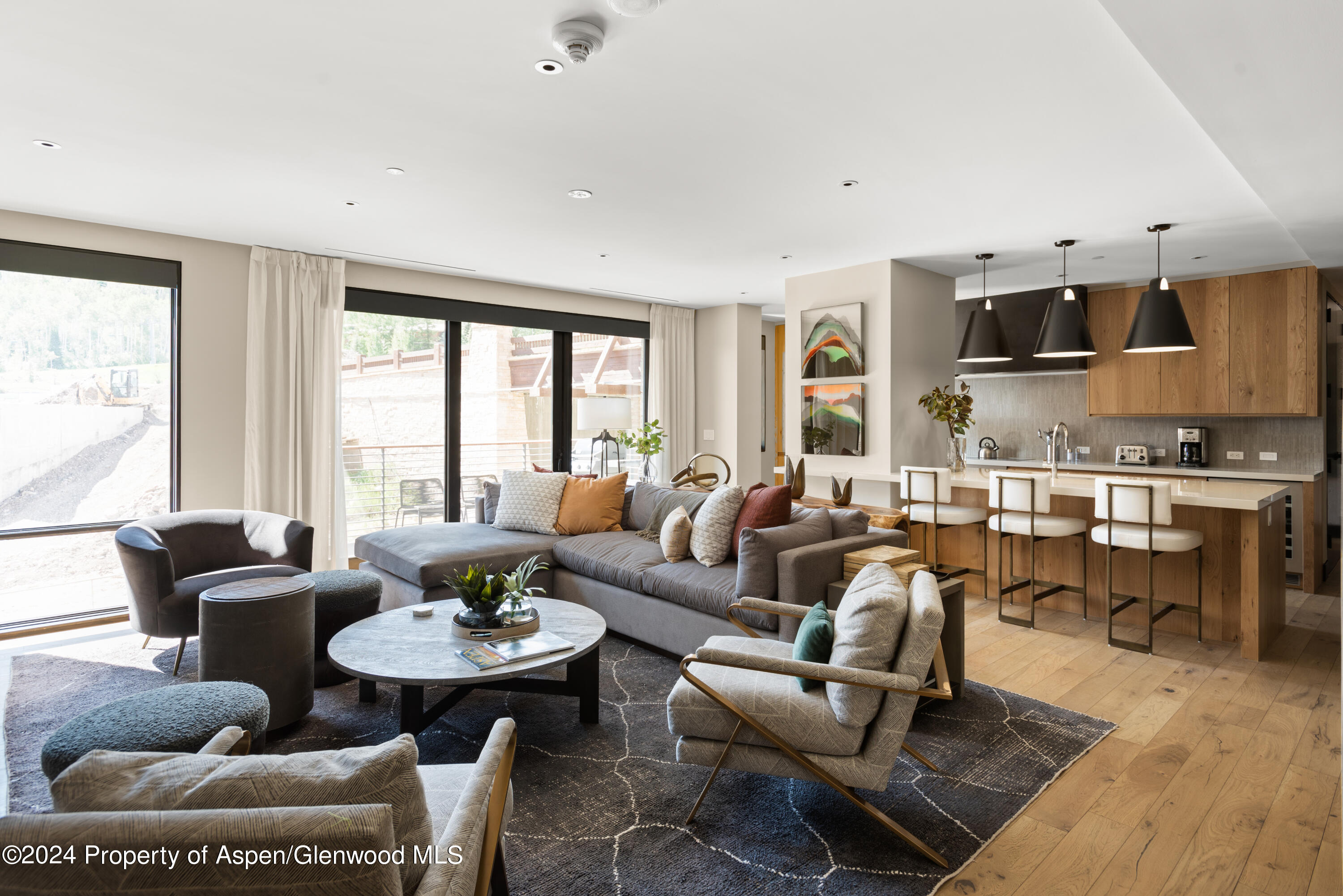 a living room with furniture kitchen view and a large window