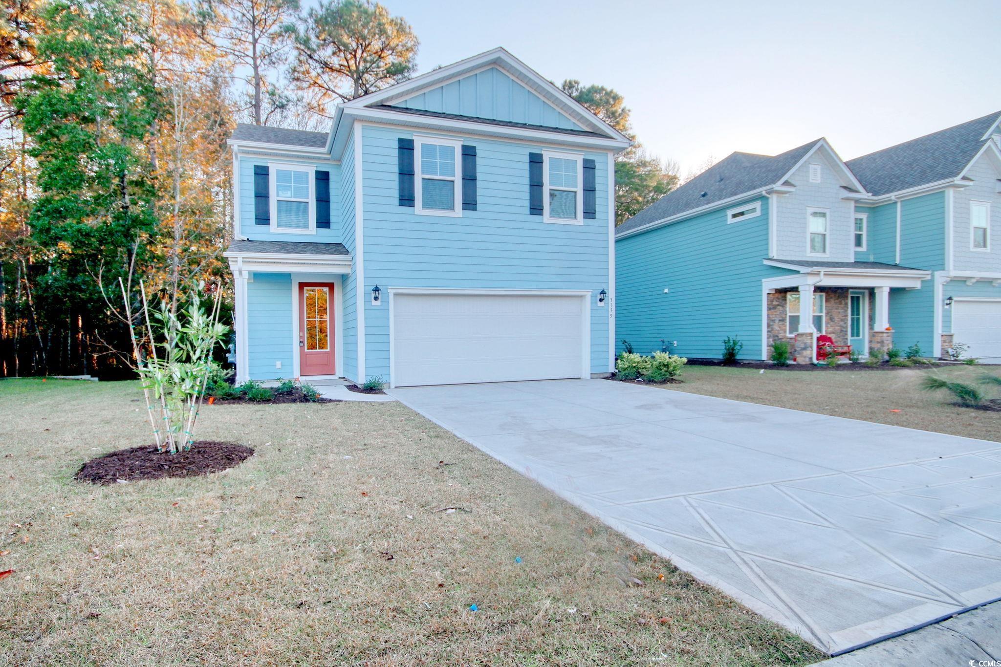 Front of property featuring a front lawn and a gar