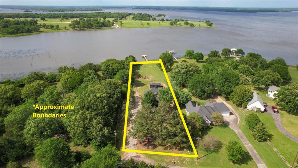 an aerial view of a residential houses with outdoor space and lake view