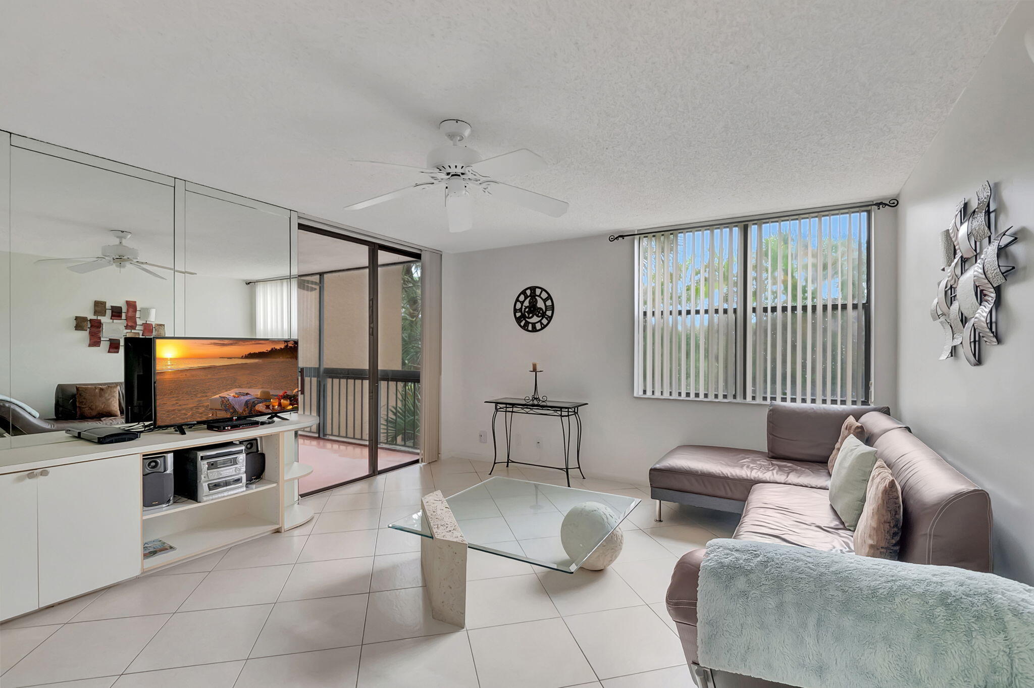 a living room with furniture a flat screen tv and a window